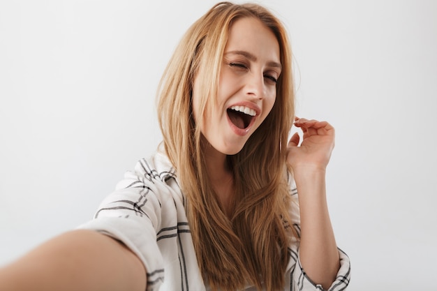 Gioiosa giovane donna casual prendendo selfie