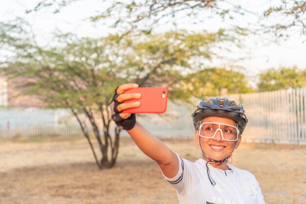 Gioiosa motociclista che si fa un selfie al tramonto