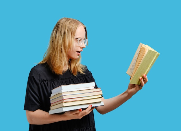 Gioioso studente caucasico con libri in mano.