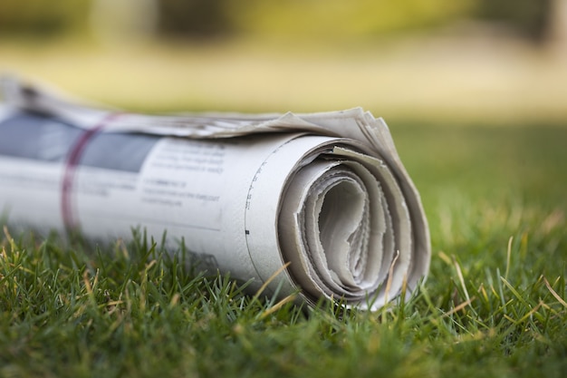 Giornale su sfondo verde erba all'aperto