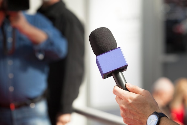 Giornalista con il microfono per condurre un'intervista