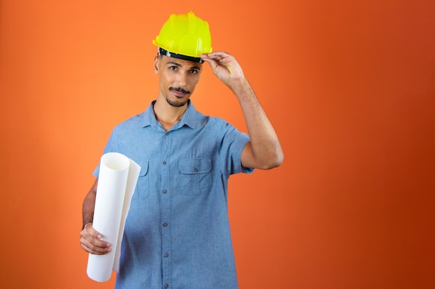 Giornata degli ingegneri Uomo nero con casco di sicurezza e camicia blu isolata Ingegnere che tiene un pannello solare fotovoltaico