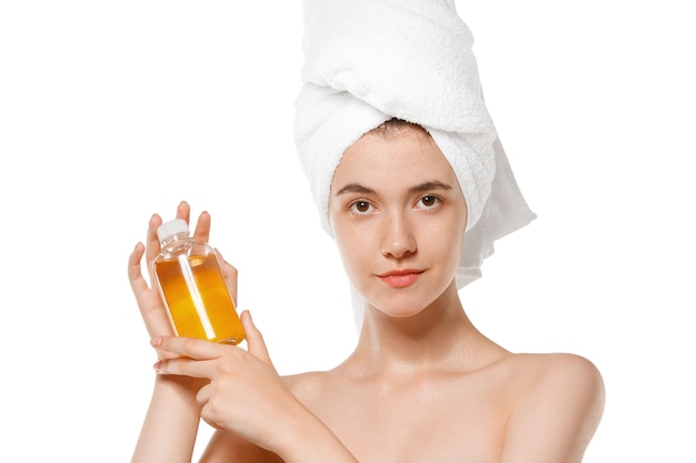 Giornata della bellezza. Giornata della bellezza. Donna che indossa asciugamano facendo la sua routine quotidiana per la cura della pelle isolata su sfondo bianco per studio. Concetto di bellezza, cura di sé, cosmetici, gioventù, spa. Bellezza naturale, sano.