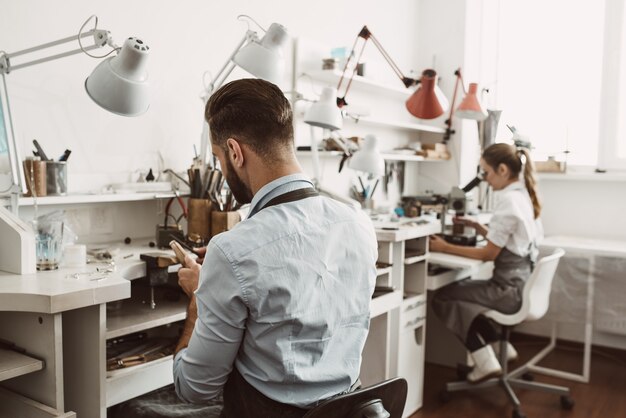 Giornata di lavoro in officina. Il team di gioiellieri sta lavorando insieme al laboratorio di creazione di gioielli. Affare