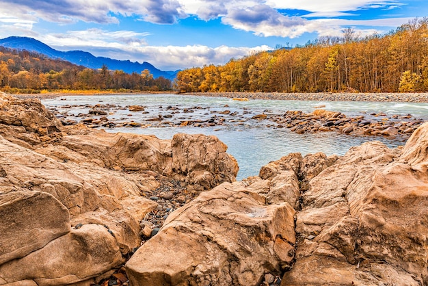 Giornata di sole autunnale in una zona boscosa di montagna con un fiume