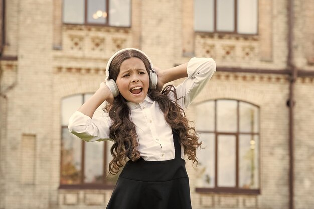 Giornata internazionale dei bambini Canta con me Allievo sorridente Vero successo Canzone felice Tempo libero e riposo Ragazzo felice all'aperto Studentessa allegra Studentessa che ascolta musica Concetto di infanzia felice