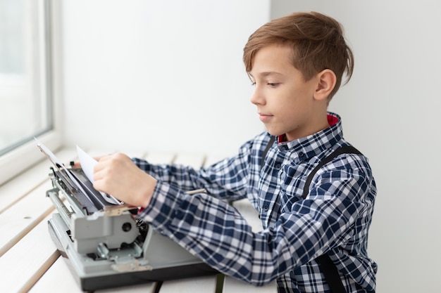 Giornata mondiale del concetto di scrittore - Ragazzo con una vecchia macchina da scrivere sulla superficie della finestra