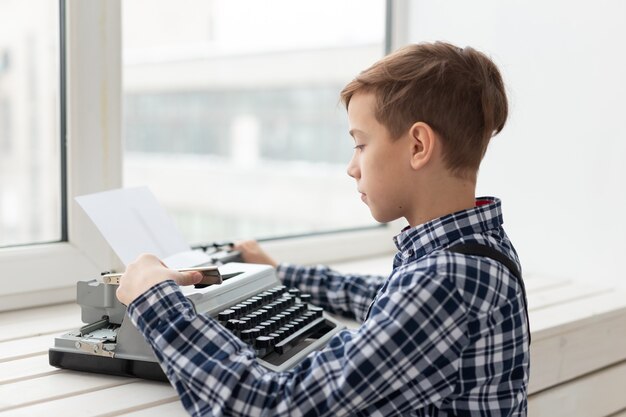 Giornata mondiale del concetto di scrittore - Ragazzo con una vecchia macchina da scrivere