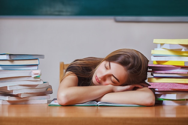 Giornata mondiale del libro. La giovane donna si addormentò mentre leggeva libri al tavolo