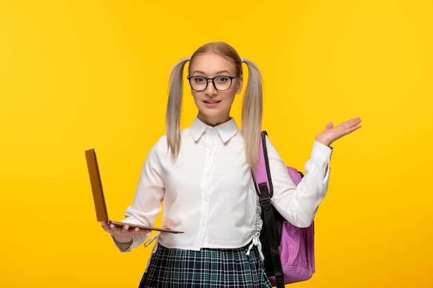 Giornata mondiale del libro sorridente studentessa felice agitando le mani e tenendo un computer