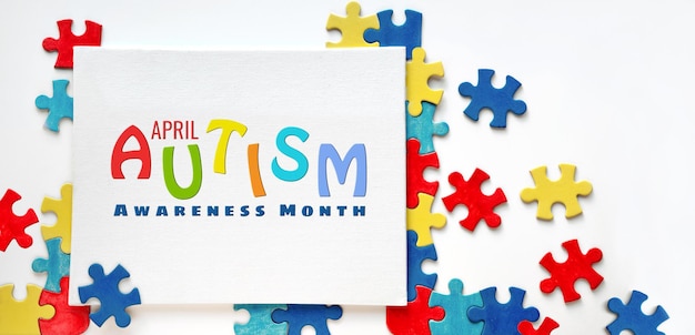 Giornata Mondiale della Consapevolezza dell'Autismo 2 aprile scritta su tela con pezzi del puzzle Design del poster del volantino per la campagna di sensibilizzazione sull'assistenza sanitaria per il disturbo autistico