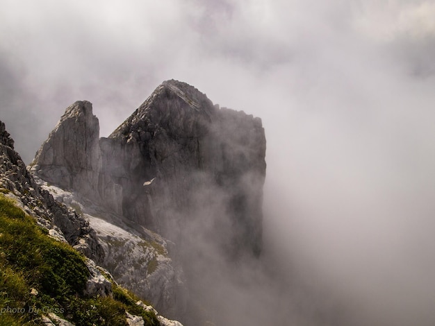 Giornata nebbiosa in montagna Picco di montagna fa capolino tra le nuvole