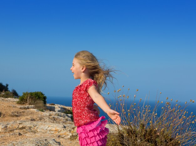 giorno blu con ragazza bambino aprire le mani al vento