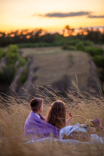 Giorno dei bambini. I bambini al tramonto si siedono a fare un picnic.