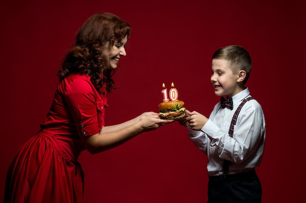 giorno del fast food, giorno dell'hamburger, giorno dell'hamburger. ritratto del primo piano di mamma e figlio con fast food nelle loro mani