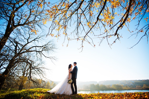 Giorno del matrimonio. Matrimonio. Passeggiata nuziale all'aperto. Sposi novelli con bouquet di fiori. Ritratto di sposi. Amore, sentimenti, tenerezza. Legame matrimoniale