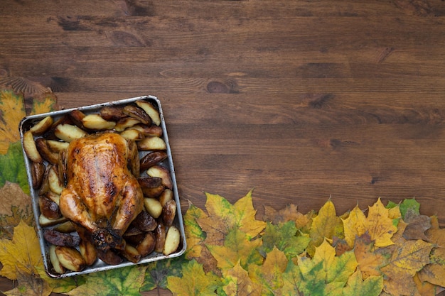 Giorno del ringraziamento con delizioso pollo alla griglia sullo sfondo di foglie autunnali e zucca raccolta.