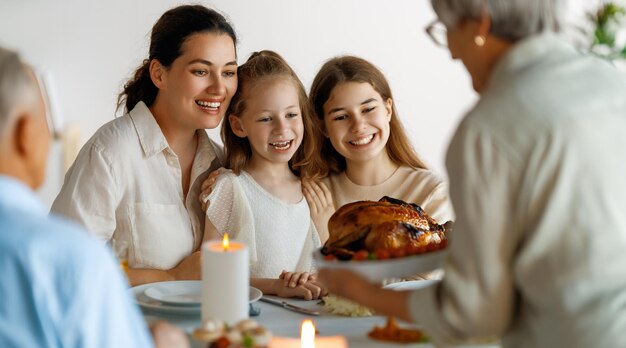 Giorno del Ringraziamento Festa d'autunno Famiglia felice seduta a tavola e celebrando la festa