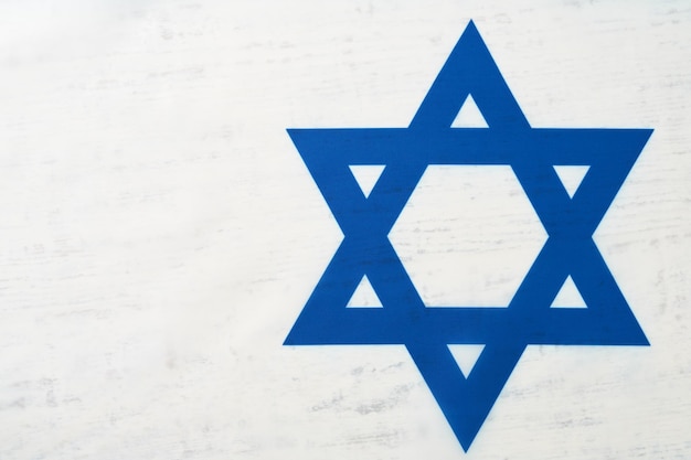 Giorno dell'indipendenza di Israele Bandiera nazionale di Israele con la stella di David su sfondo bianco in legno Primo piano Bandiera nazionale con posto per il testo