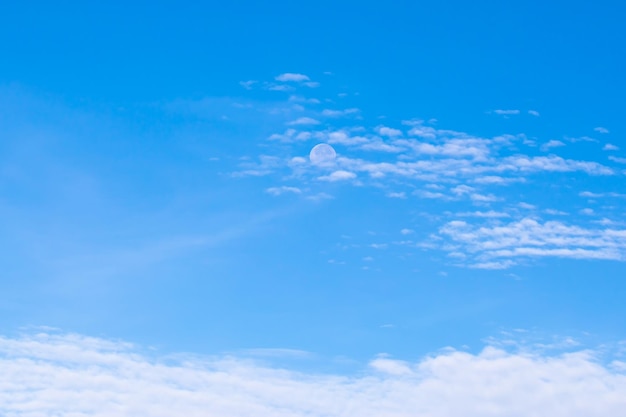 Giorno di luna contro un cielo blu con nuvole Cirrus Cumulus