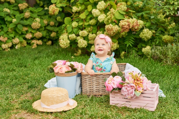 Giorno di protezione dei bambini, bambina nel parco si siede in un cestino su un picnic estivo