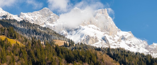 Giorno limpido alla stazione sciistica di Engelberg, in Svizzera, con cime innevate e foreste