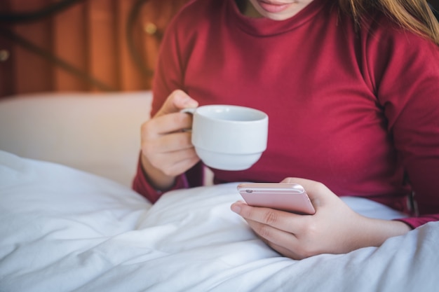 giorno luminoso di una giovane donna che tiene e utilizzando smartphone