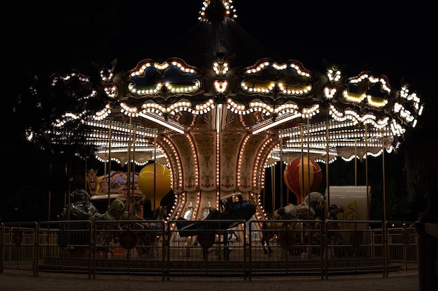 Giostra retrò la sera d'estate, luci di giostra vintage nel parco.