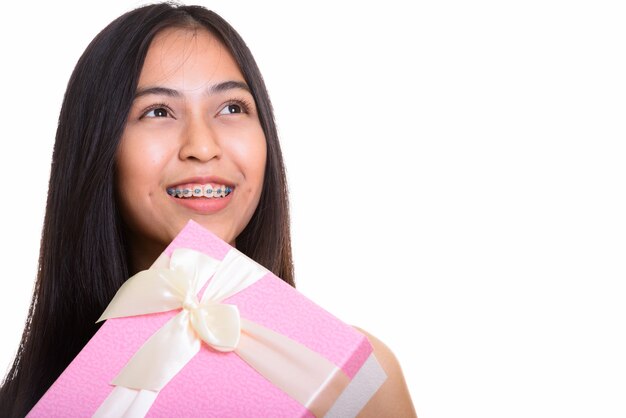 Giovane adolescente asiatico felice premuroso che sorride mentre tiene un presente