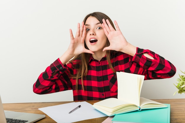 Giovane adolescente che torna alla sua routine facendo i compiti gridando eccitato al fronte.