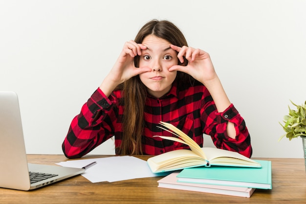 Giovane adolescente che torna alla sua routine facendo i compiti tenendo gli occhi aperti.