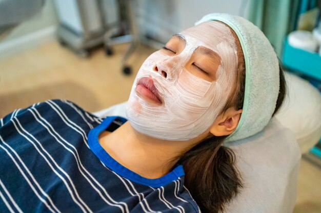 Giovane adolescente femminile asiatico che ottiene la sua acne