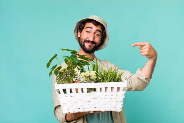 Giovane adulto ispanico pazzo con il concetto di giardinaggio delle piante