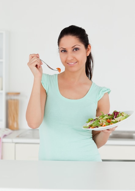 Giovane adulto mangiando insalata