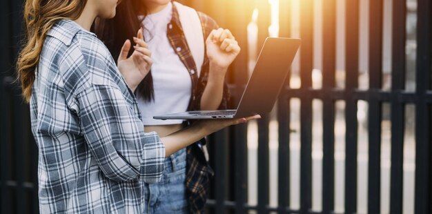 Giovane adulto sorridente felice studente asiatico ispanico che indossa le cuffie parlando in chat online riunione utilizzando il laptop nel campus universitario o in ufficio virtuale Studentessa universitaria che impara a distanza