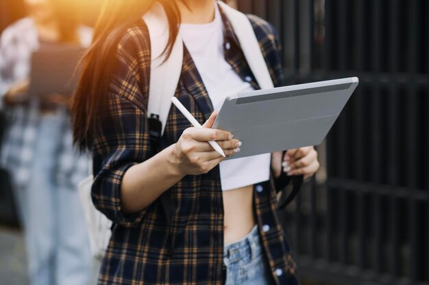 Giovane adulto sorridente felice studente asiatico ispanico che indossa le cuffie parlando in chat online riunione utilizzando il laptop nel campus universitario o in ufficio virtuale Studentessa universitaria che impara a distanza