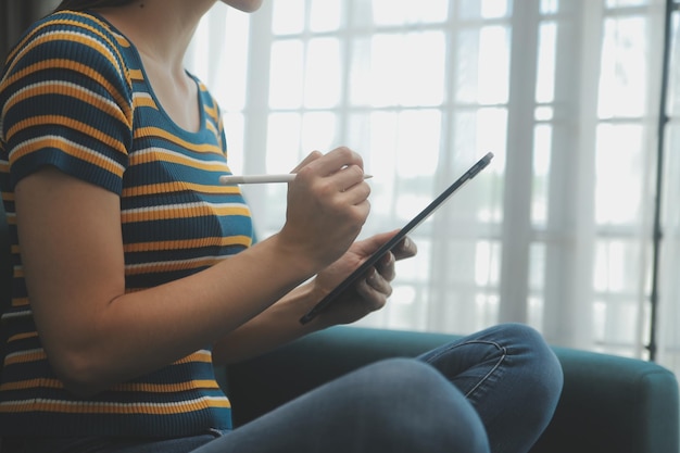 Giovane adulto sorridente felice studente asiatico ispanico che indossa le cuffie parlando in chat online riunione utilizzando il laptop nel campus universitario o in ufficio virtuale Studentessa universitaria che impara a distanza