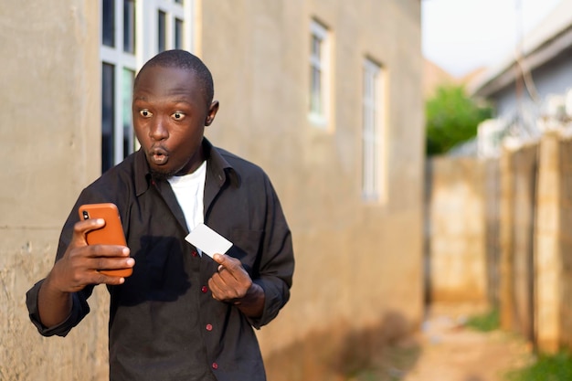 Giovane africano sovraeccitato che guarda il cellulare