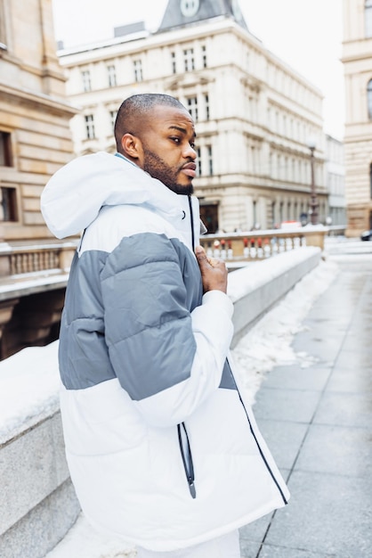 Giovane africano sul ritratto della città di stagione invernale della neve della via