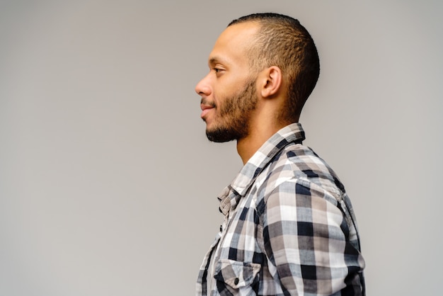 Giovane afro-americano che indossa una camicia casual su grigio chiaro