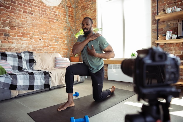 Giovane afroamericano che insegna a casa corsi online di fitness