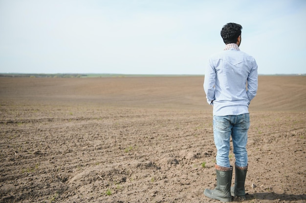 Giovane agricoltore indiano al campo agricolo