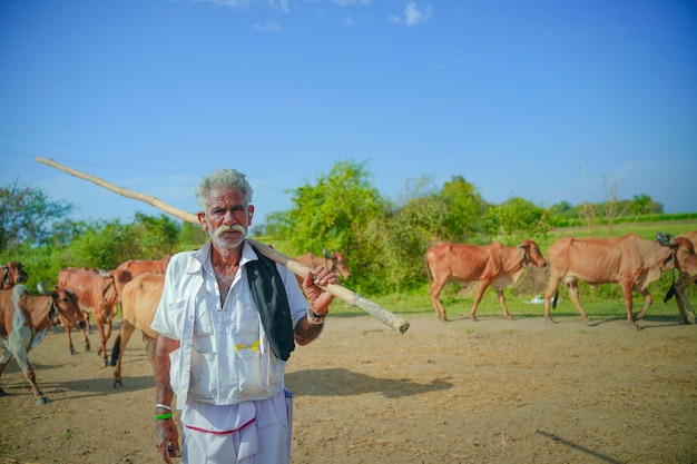 Giovane agricoltore indiano con il suo bestiame