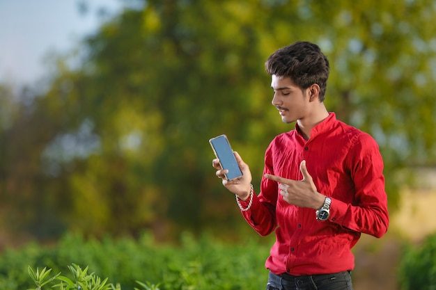 Giovane agronomo indiano con lo smartphone