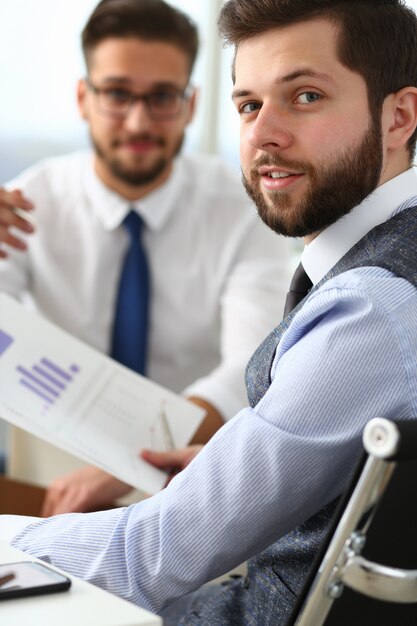 Giovane allegro che lavora con il collega in ufficio