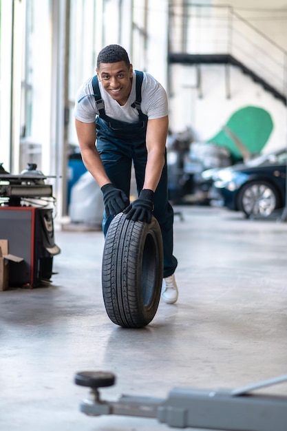 Giovane allegro che lavora nell'officina riparazioni auto