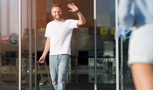 Giovane amico di saluto che arriva all'aeroporto