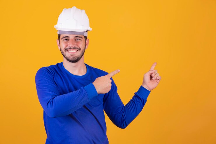 Giovane architetto con casco che punta di lato