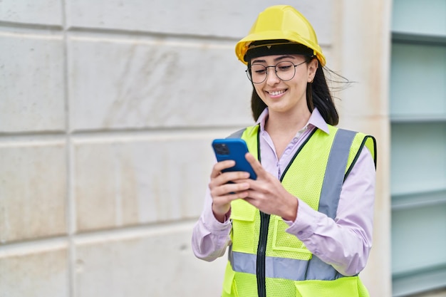 Giovane architetto ispanico della donna che utilizza smartphone alla via