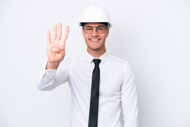 Giovane architetto uomo caucasico con casco e azienda progetti isolati su sfondo bianco felice e contando quattro con le dita